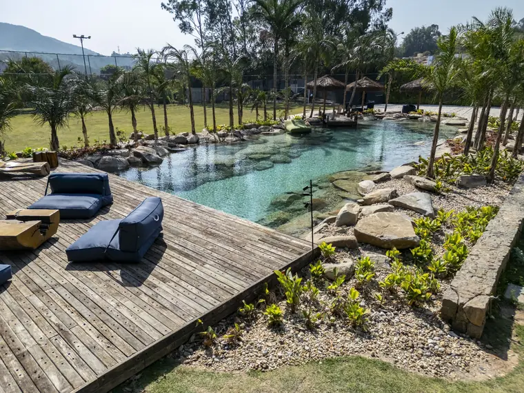 Espaço aquático natural com deck e vegetação tropical