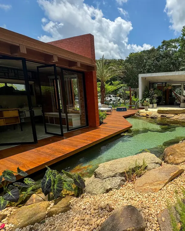 Relação entre a arquitetura de uma residência em Aldeia e o lago com deck
